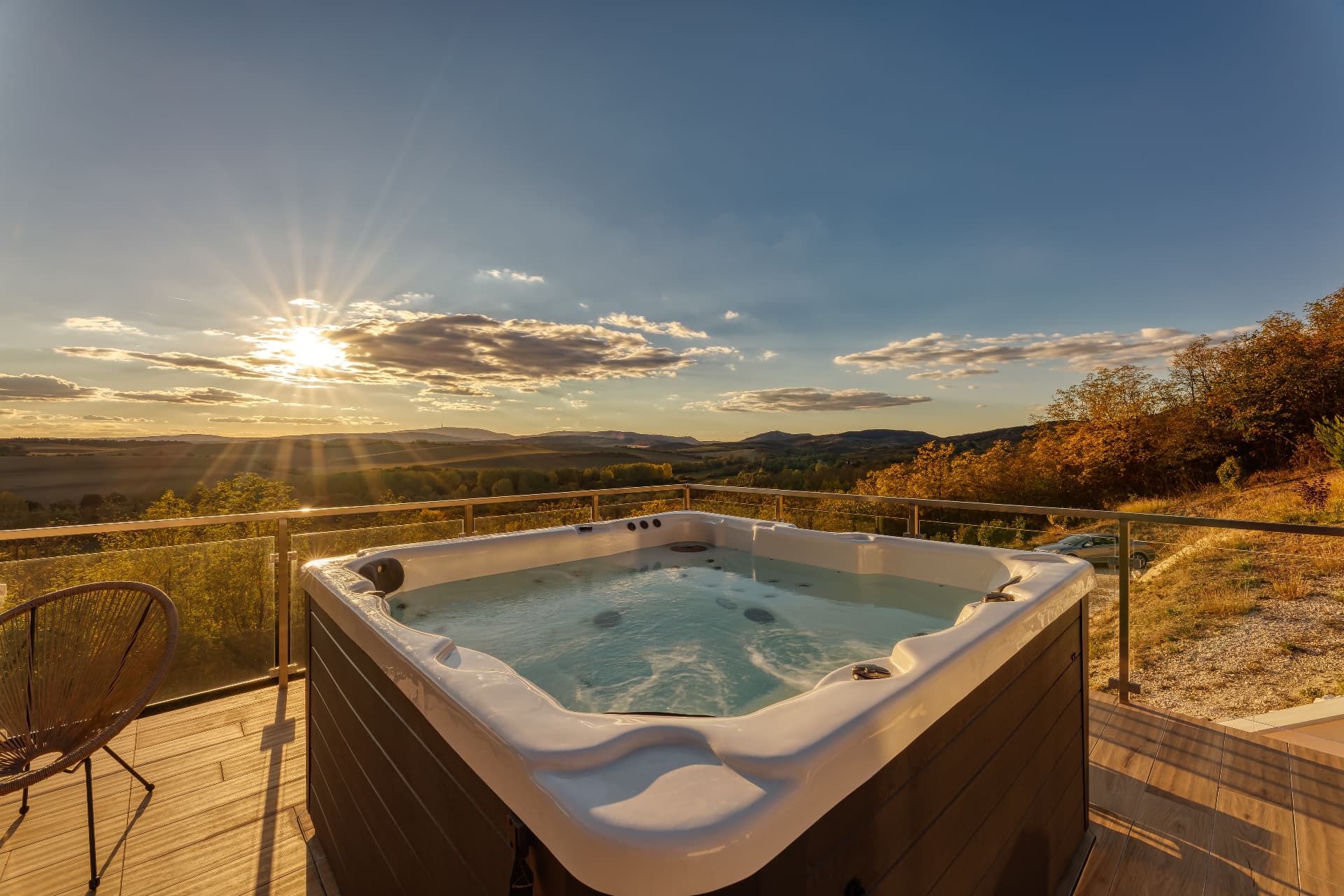 Kültéri jacuzzi a teraszon, naplementében, a mezőre nyíló panorámával